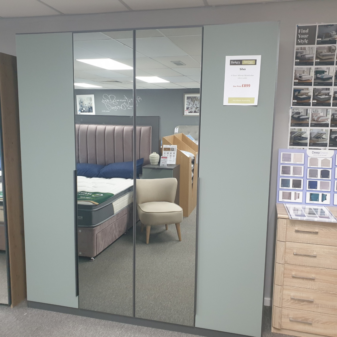 A 4-door sage green wardrobe with a mirrored front